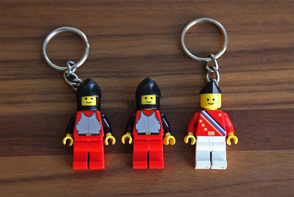 Imagen de unos llaveros con figuras de lego en una superficie marron